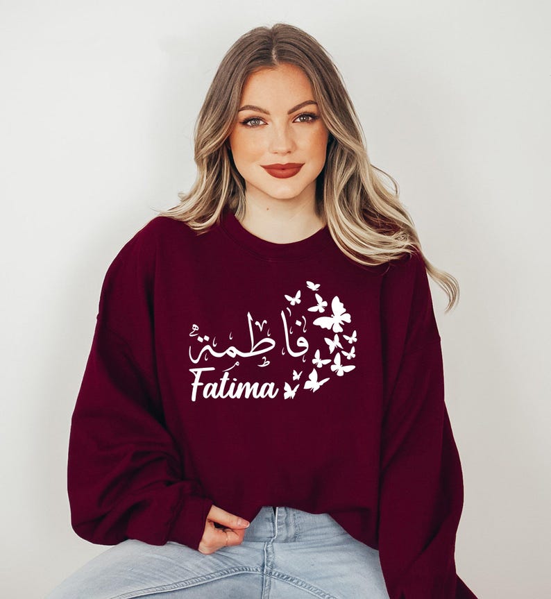 Personalised Arabic Name Sweatshirt celebrating faith, identity, culture, and personal expression through elegant Arabic calligraphy and beautiful butterfly illustrations. Featuring your chosen Arabic name printed on a premium sweatshirt, this meaningful design creates a lasting keepsake while combining modest fashion, individuality, comfort, and spiritual inspiration in a stylish personalised garment.