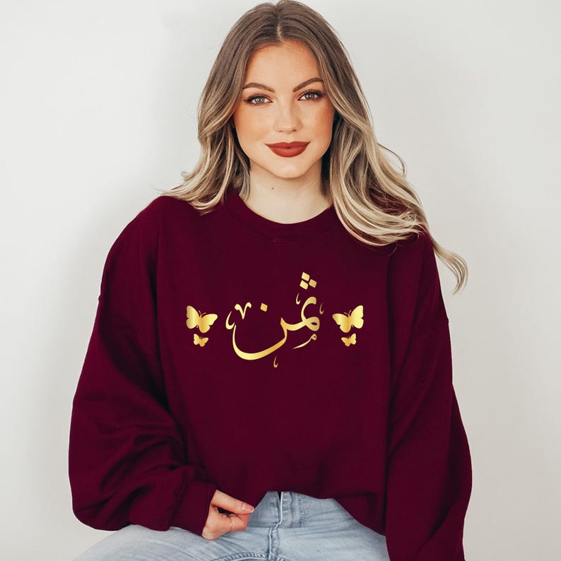 Personalised Arabic Name Sweatshirt celebrating faith, identity, culture, and personal expression through elegant Islamic calligraphy and graceful butterfly artwork. Featuring your chosen Arabic name printed on a premium sweatshirt, this meaningful design creates a lasting keepsake while combining modest fashion, individuality, comfort, and spiritual inspiration in a stylish personalised garment.