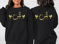 Custom Arabic Text Sweatshirt designed for modern modest fashion and comfortable everyday wear. Perfect for Eid celebrations, Ramadan gatherings, family events, university life, travel, shopping trips, casual outings, and relaxed weekends. This personalised sweatshirt combines elegant Arabic typography, butterfly-inspired artwork, premium comfort, and timeless Islamic fashion for a stylish and meaningful look.