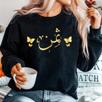 Personalised Arabic Calligraphy Sweatshirt featuring elegant butterfly artwork and custom Arabic name design. Premium unisex sweatshirt personalised with your chosen Arabic text, combining Islamic calligraphy, modest fashion, and meaningful personalised clothing. Designed for comfort and style, this Arabic sweatshirt is perfect for everyday wear, family gatherings, special occasions, and women who appreciate faith-inspired fashion with a personal touch.