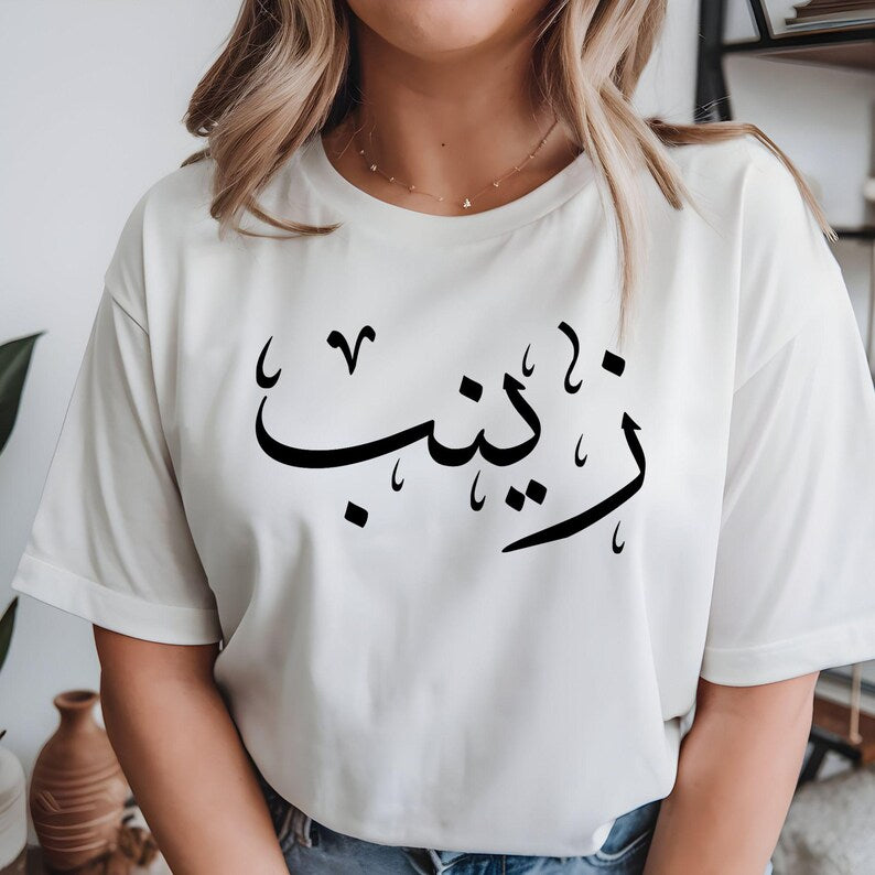Personalised Arabic Calligraphy Name T Shirt featuring a custom Arabic name printed on the front chest and a larger matching design on the back. This custom Arabic shirt is professionally printed and makes a meaningful Muslim gift, Eid gift, Ramadan gift, or personalised keepsake for family and friends who appreciate Arabic calligraphy and Islamic clothing.