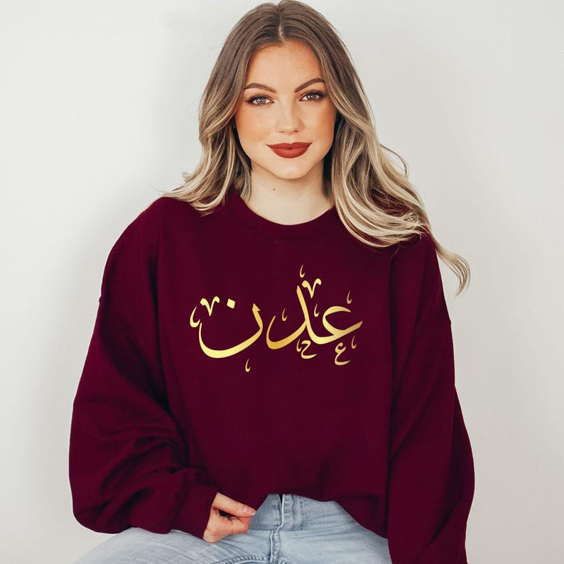 Personalised Arabic Name Sweatshirt celebrating faith, identity, culture, and personal expression through elegant Arabic calligraphy. Featuring your chosen Arabic name printed on a premium sweatshirt, this meaningful design creates a lasting keepsake while combining modest fashion, individuality, comfort, and cultural pride. A beautiful personalised garment designed to reflect personal style and meaningful connections.