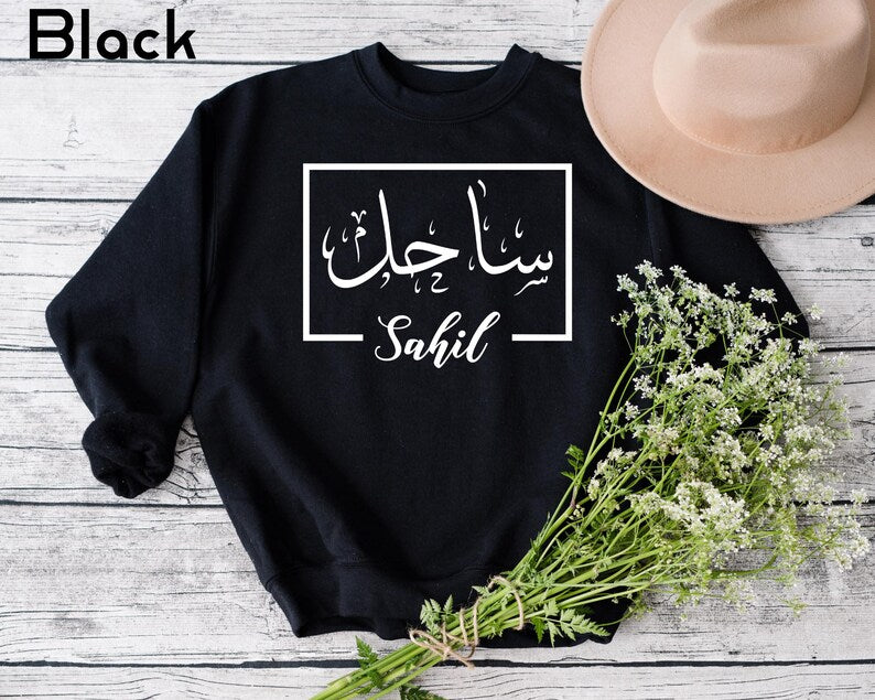 Personalised Arabic Calligraphy Name Sweatshirt featuring elegant Arabic typography and meaningful Islamic-inspired styling. Customised with your chosen Arabic name, this premium sweatshirt reflects faith, identity, culture, and personal expression through beautiful Arabic script. Perfect for Muslim women seeking modest fashion, personalised Islamic clothing, faith-based apparel, and stylish everyday wear.