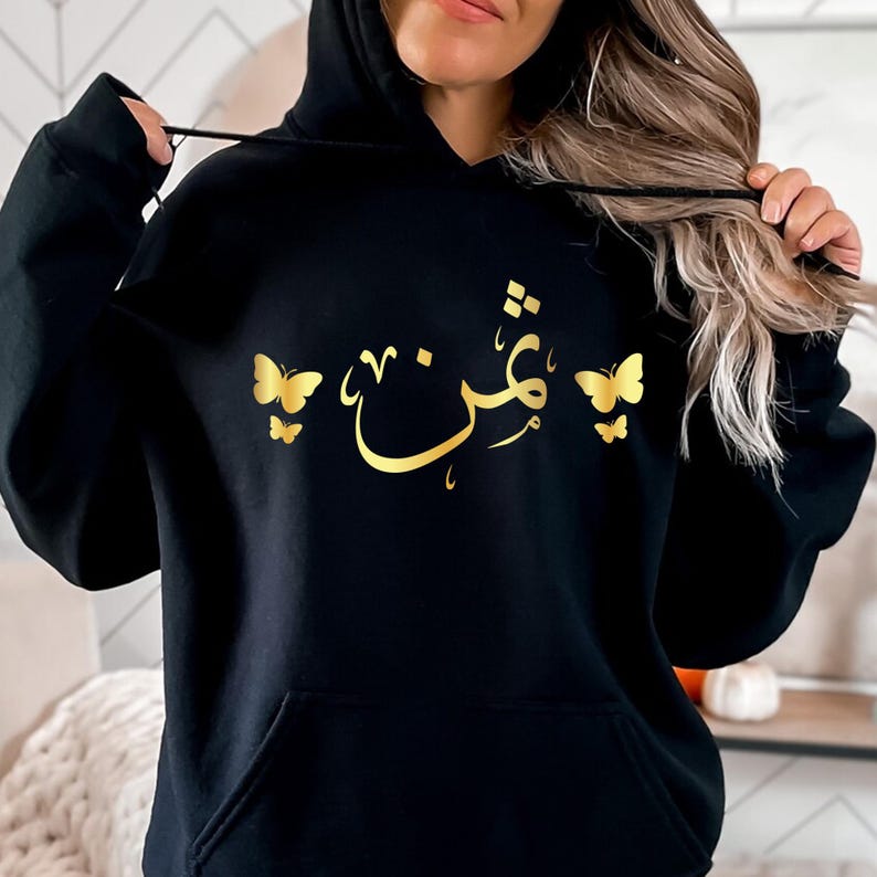 Personalised Arabic Name Butterfly Hoodie designed for Muslim women, Arabic speakers, Islamic fashion lovers, daughters, sisters, mothers, students, and anyone who appreciates meaningful personalised clothing. Featuring elegant Arabic calligraphy combined with delicate butterfly artwork, this premium hoodie offers a stylish blend of modest fashion, personalised design, and cultural expression. Perfect for women searching personalised Arabic hoodies, Islamic gifts for her, Muslim fashion apparel, custom Arab