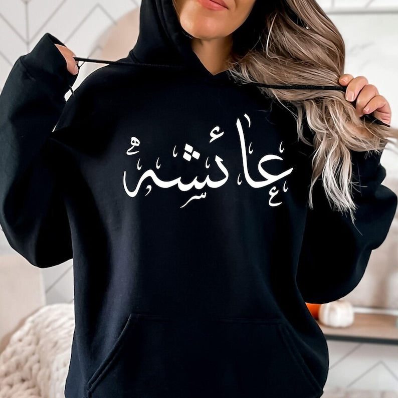 Personalised Arabic Name Hoodie designed for Muslims, Arabic speakers, Islamic fashion lovers, students, family members, friends, and anyone who appreciates meaningful personalised clothing. Featuring a bold Arabic calligraphy name design printed across the chest, this premium hoodie combines cultural identity, personal expression, and modern fashion styling. Perfect for customers searching personalised Arabic clothing, Arabic name apparel, Muslim fashion hoodies, Islamic gifts, custom Arabic typography gar