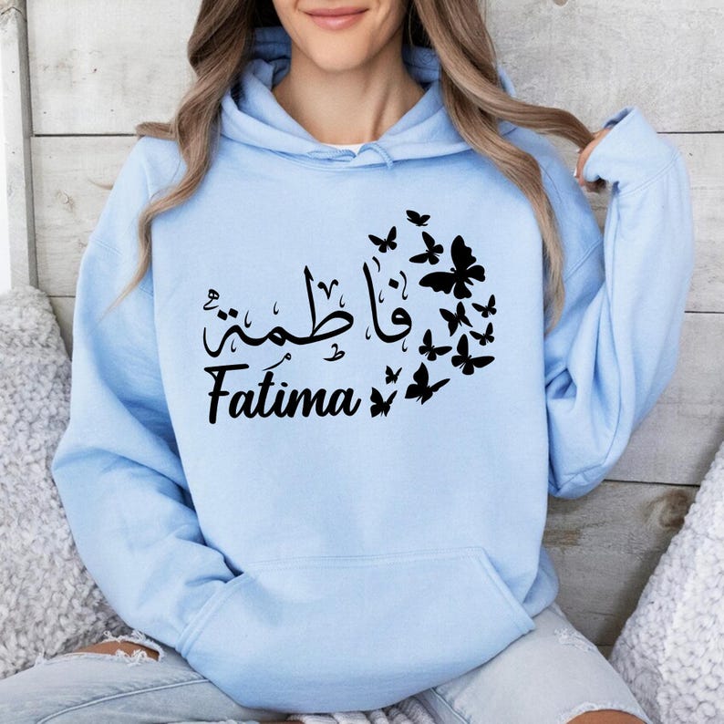 Custom Arabic Name Butterfly Hoodie ideal for Eid celebrations, Ramadan gatherings, family events, holidays, travel, university life, casual outings, and everyday wear. The elegant Arabic calligraphy design paired with delicate butterfly details creates a fashionable and meaningful garment suitable for both special occasions and daily fashion. Designed for comfort and style, this personalised hoodie offers a timeless look throughout every season.