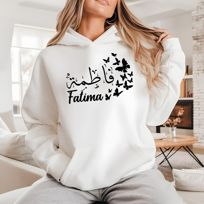 Personalised Arabic Name Butterfly Hoodie designed for Muslim women, Arabic speakers, Islamic fashion lovers, daughters, sisters, mothers, students, and anyone who appreciates meaningful personalised clothing. Featuring elegant Arabic calligraphy combined with delicate butterfly artwork, this premium hoodie offers a stylish blend of modest fashion, personalised design, and cultural expression. Perfect for women searching personalised Arabic hoodies, Islamic clothing, Muslim fashion apparel, and unique custo