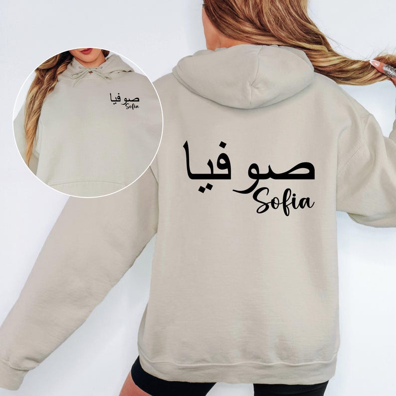 Elegant personalised Arabic name hoodie showcasing premium Arabic calligraphy printed as a coordinated left chest and large back design. The minimalist layout combines traditional Arabic script with modern typography to create a sophisticated and eye-catching appearance. The balanced front and back placement provides a stylish, contemporary look while maintaining a clean and timeless aesthetic.