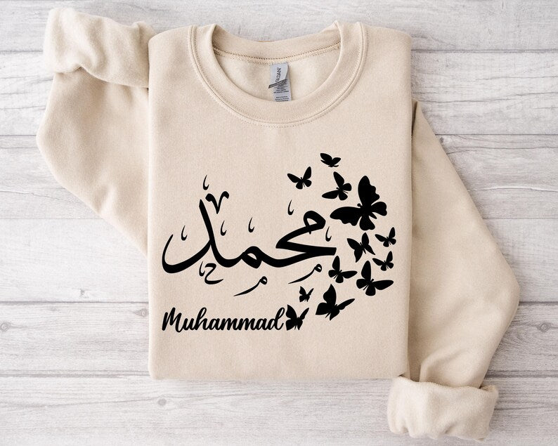 Personalised Arabic Calligraphy Sweatshirt designed with elegant butterfly artwork and custom Arabic typography, creating a unique and meaningful personalised clothing piece. Perfect for Eid gifts, Ramadan presents, birthdays, anniversaries, Christmas gifting, and special family occasions. Combining premium comfort, modest fashion styling, Islamic-inspired design, and personalised Arabic calligraphy, this sweatshirt is a thoughtful gift choice for Muslim women who appreciate meaningful and stylish apparel.