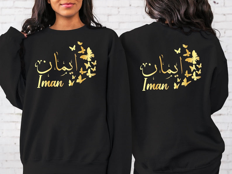 Custom Arabic Text Sweatshirt designed for modern modest fashion and comfortable everyday wear. Perfect for Eid celebrations, Ramadan gatherings, family events, university life, travel, shopping trips, casual outings, and relaxed weekends. This personalised sweatshirt combines elegant Arabic typography, butterfly-inspired artwork, premium comfort, and timeless Islamic fashion for a stylish and meaningful look.