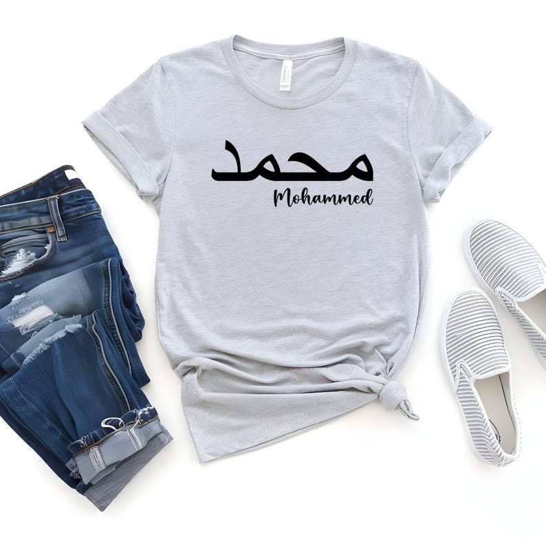 Personalised Arabic Name T Shirt featuring elegant Arabic typography designed to transform your chosen name into a meaningful and stylish piece of wearable art. The combination of flowing Arabic calligraphy and personalised name styling creates a premium garment that celebrates culture, identity, beauty, and individuality. Perfect for customers searching Arabic typography shirts, personalised Arabic clothing, custom Arabic name apparel, Islamic fashion, and unique personalised gifts.