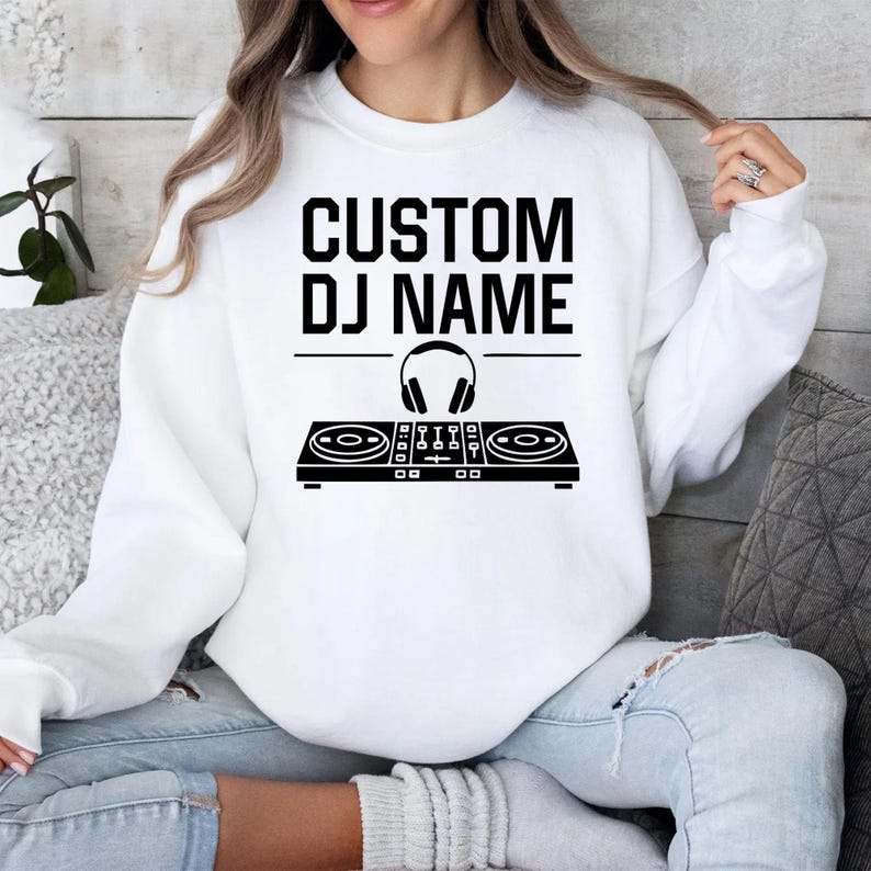 Designed for DJs, music producers, festival performers and electronic music lovers, this personalised sweatshirt features a custom DJ name above a professional controller and headphones graphic. Perfect for performances, studio sessions and everyday outfits. Every premium crewneck is professionally printed in the UK by TeezoraPrints using high-quality materials.