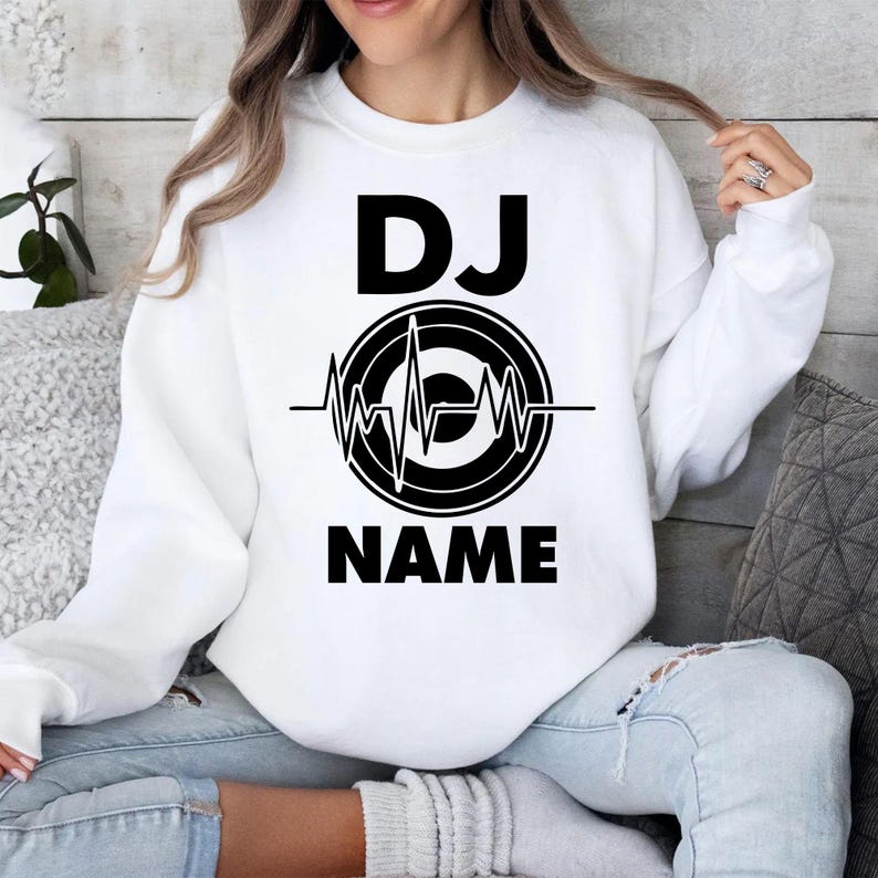 Designed for DJs, producers, festival performers and electronic music fans, this personalised sweatshirt features a custom DJ name with a heartbeat turntable graphic. Ideal for performances, studio sessions and everyday outfits, every premium crewneck is professionally printed in the UK by TeezoraPrints using high-quality fabric for lasting comfort and durability.