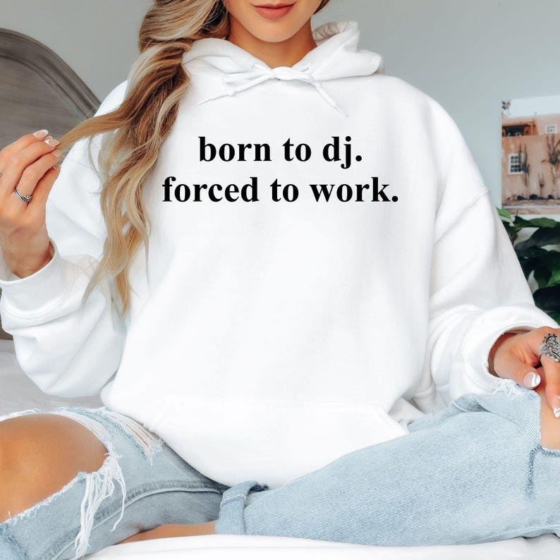 Created for DJs, music producers, club performers and electronic music enthusiasts, this Born To DJ. Forced To Work. Hoodie combines humour with everyday comfort. Featuring a clean minimalist quote, this premium hoodie is perfect for anyone whose true passion is music. Ideal for festivals, studio sessions, live performances and casual wear, every hoodie is professionally printed in the UK by TeezoraPrints using premium-quality fabric for long-lasting comfort.