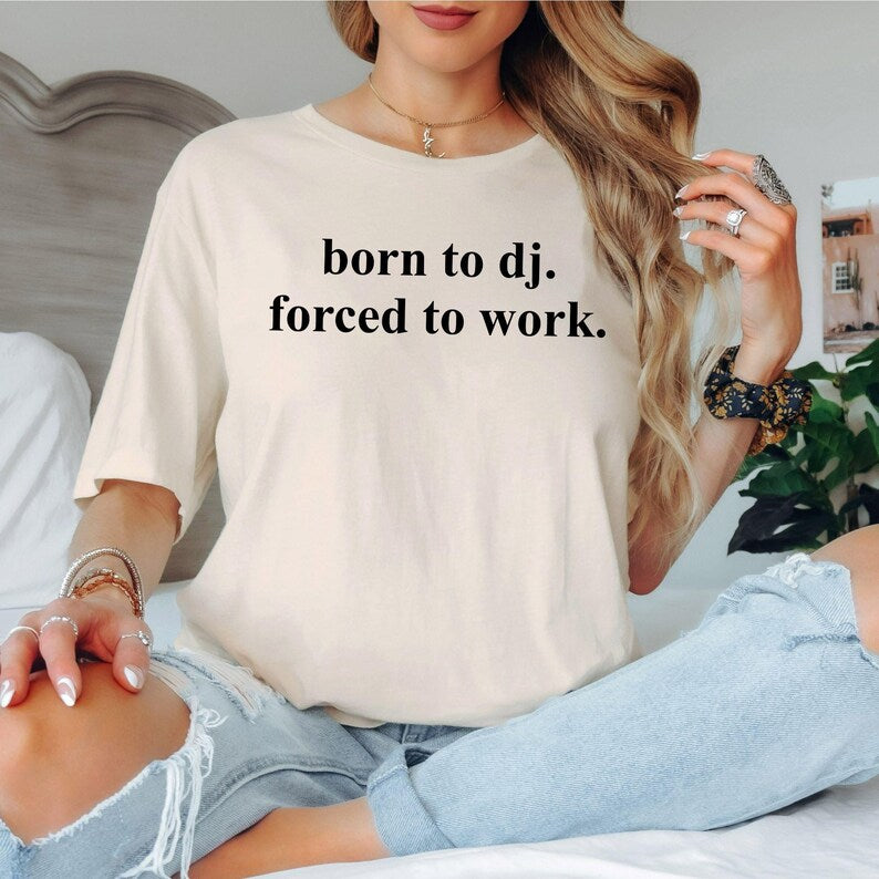 Express your passion for DJ culture with this Born To DJ Forced To Work graphic t-shirt. Whether you're mixing tracks in the studio, performing live, travelling to festivals, relaxing with friends or creating new playlists at home, this premium unisex tee delivers all-day comfort and effortless style. Every shirt is proudly printed in the UK by TeezoraPrints, making it an excellent addition to any music lover's wardrobe.