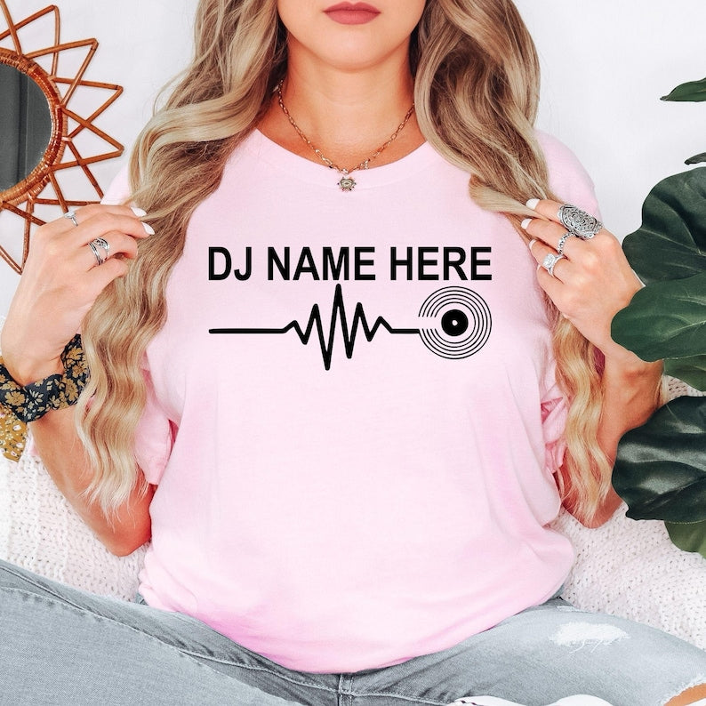 Perfect for DJ performances, club nights, music festivals, recording studios, concerts, parties and everyday casual wear. This personalised DJ Name Heartbeat T-Shirt combines custom style with premium comfort. Printed in the UK by TeezoraPrints.