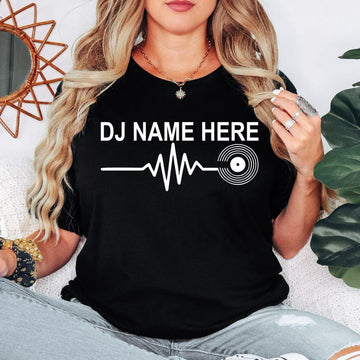 Personalised DJ Name Heartbeat T-Shirt featuring a custom DJ name, heartbeat waveform and vinyl record graphic. Designed for DJs, music producers, club performers and electronic music lovers who want a stylish personalised tee. Professionally printed in the UK by TeezoraPrints using premium-quality fabric for exceptional comfort, durability and everyday wear.
