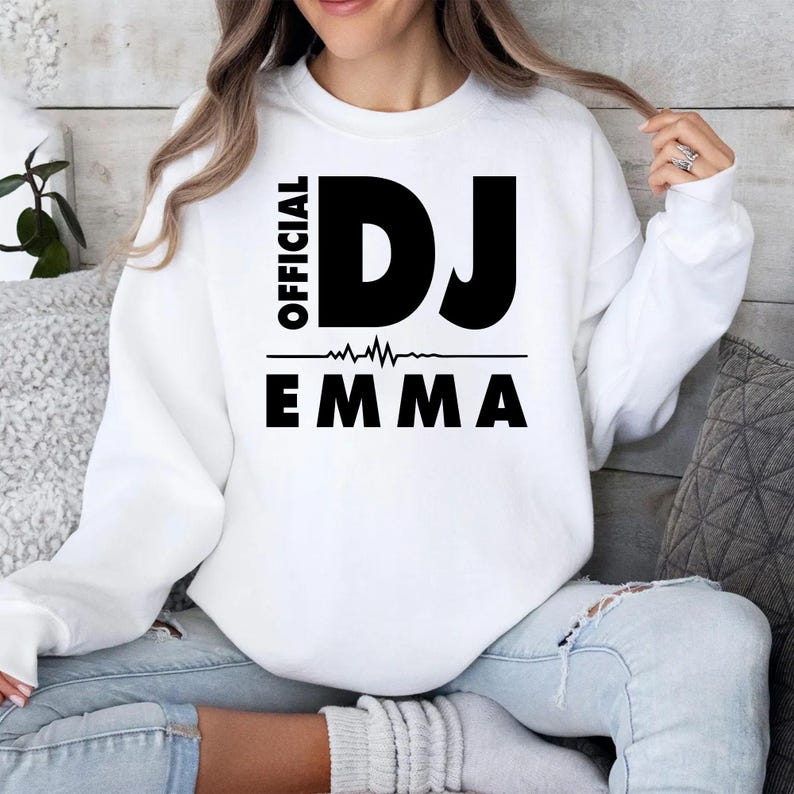 Personalised Official DJ Heartbeat Sweatshirt featuring a custom name, bold Official DJ typography and a heartbeat waveform graphic. Designed for professional DJs, music producers, club performers and electronic music lovers who want to showcase their passion with a personalised premium crewneck. Professionally printed in the UK by TeezoraPrints using high-quality materials for outstanding comfort, durability and everyday style.