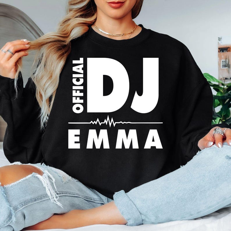 Personalised Official DJ Heartbeat Sweatshirt featuring a custom name, bold Official DJ typography and a heartbeat waveform graphic. Designed for professional DJs, music producers, club performers and electronic music lovers who want to showcase their passion with a personalised premium crewneck. Professionally printed in the UK by TeezoraPrints using high-quality materials for outstanding comfort, durability and everyday style.