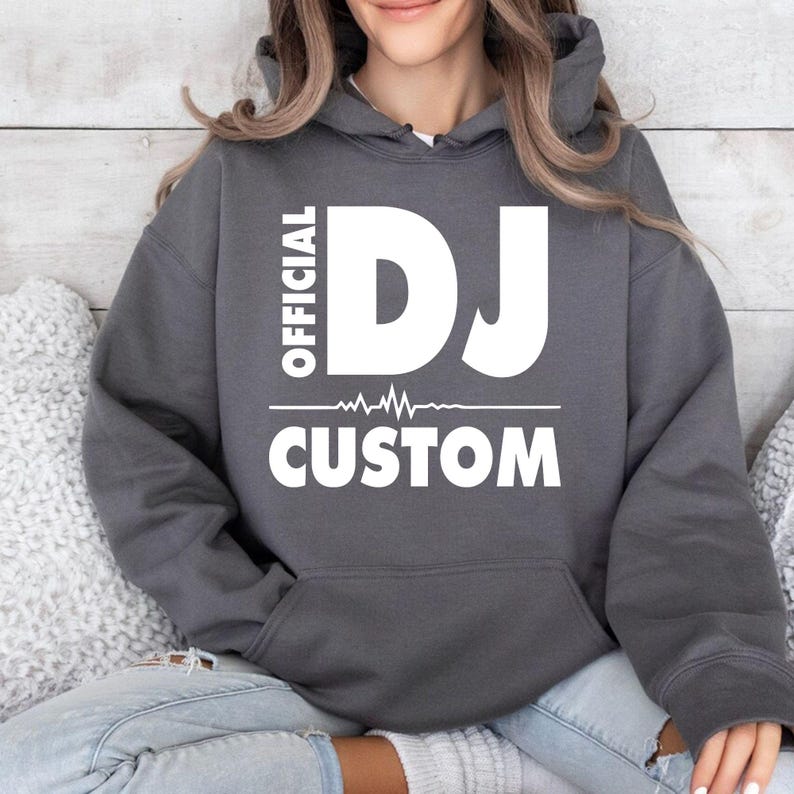 Premium personalised DJ hoodie featuring Official DJ typography, a custom name and heartbeat waveform artwork. Perfect for professional DJs, wedding DJs, mobile entertainers, club performers, music producers and festival lovers. Professionally printed in the UK by TeezoraPrints using premium materials for exceptional comfort and durability.