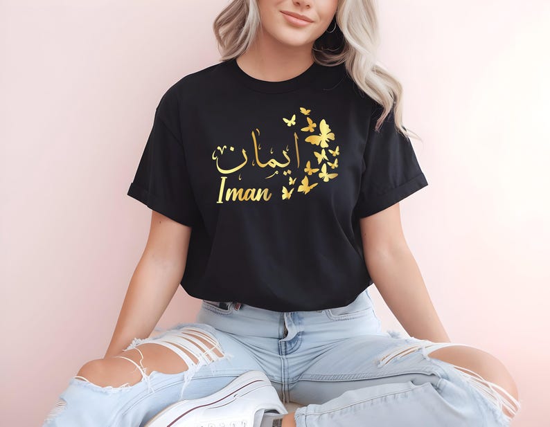Personalised Arabic Name Butterfly T Shirt designed for Muslim women, Arabic speakers, Islamic fashion lovers, students, daughters, sisters, mothers, and anyone who appreciates elegant personalised Arabic clothing. Featuring custom Arabic calligraphy combined with delicate butterfly artwork, this premium t shirt appeals to women seeking meaningful personalised gifts, stylish Islamic fashion, and unique Arabic-inspired apparel.