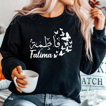 Personalised Arabic Calligraphy Sweatshirt featuring elegant butterfly artwork and custom Arabic name design. Premium unisex sweatshirt personalised with your chosen Arabic text, combining Islamic typography, modest fashion, and meaningful personalised clothing. Designed for comfort and everyday wear, this stylish Arabic sweatshirt is perfect for Muslim women seeking elegant personalised apparel with a timeless and fashionable look.