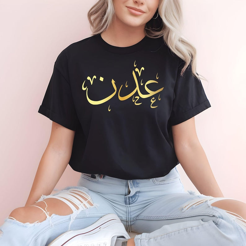 Personalised Arabic Name T Shirt designed for Muslims, Arabic speakers, Islamic fashion lovers, students, family members, friends, and anyone who appreciates elegant personalised clothing. Featuring a bold Arabic calligraphy name design printed across the chest, this premium t shirt combines cultural identity with modern fashion styling. Perfect for customers searching personalised Arabic clothing, Arabic name apparel, Muslim fashion shirts, Islamic gifts, and meaningful custom garments that celebrate herit