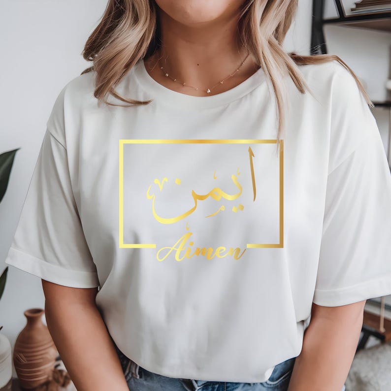 Personalised Arabic name t shirt designed for women, Muslim girls, Arabic culture lovers and anyone looking for meaningful custom clothing. This elegant black shirt features a gold Arabic calligraphy name design inside a modern frame, creating a stylish and personal fashion statement. Perfect for daughters, sisters, wives, friends and family members who appreciate personalised apparel that combines cultural identity, fashion and individuality.