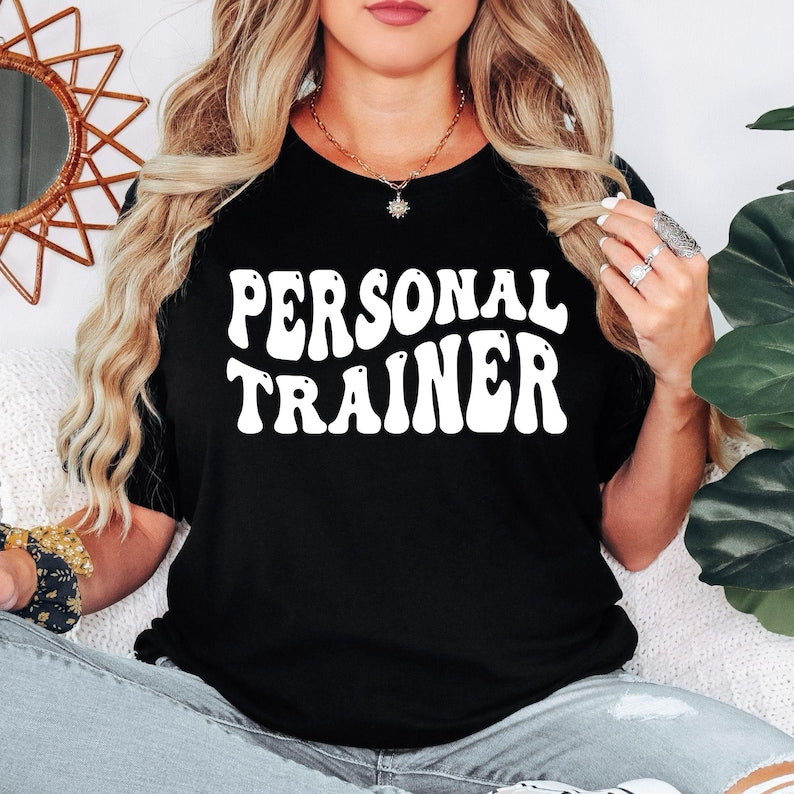 Personal Trainer T Shirt created for certified personal trainers, fitness coaches, gym instructors, strength coaches, wellness professionals, bodybuilding enthusiasts, gym owners, and fitness lovers who inspire others every day. Featuring bold retro typography, this premium graphic tee from Teezora Prints combines exceptional comfort, premium print quality, and stylish athletic fashion, making it ideal for professionals working in gyms, fitness studios, boot camps, and personal training sessions.