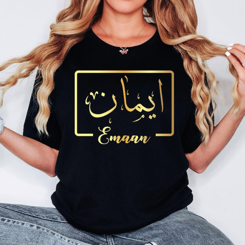 Personalised Arabic Name T Shirt designed for Muslim women, Arabic culture enthusiasts, and anyone seeking meaningful personalised clothing. This elegant black t shirt features a custom Arabic calligraphy name design printed in luxurious gold within a minimalist frame. Perfect for daughters, sisters, wives, mothers, friends, and loved ones who appreciate personalised apparel that combines identity, culture, comfort, and timeless style while expressing individuality through elegant Arabic typography.