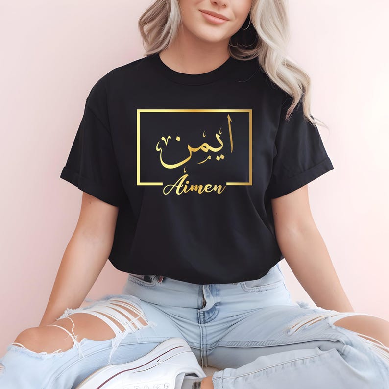 Personalised Arabic name t shirt designed for women, Muslim girls, Arabic culture lovers and anyone looking for meaningful custom clothing. This elegant black shirt features a gold Arabic calligraphy name design inside a modern frame, creating a stylish and personal fashion statement. Perfect for daughters, sisters, wives, friends and family members who appreciate personalised apparel that combines cultural identity, fashion and individuality.