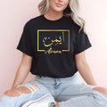Personalised Arabic name t shirt designed for women, Muslim girls, Arabic culture lovers and anyone looking for meaningful custom clothing. This elegant black shirt features a gold Arabic calligraphy name design inside a modern frame, creating a stylish and personal fashion statement. Perfect for daughters, sisters, wives, friends and family members who appreciate personalised apparel that combines cultural identity, fashion and individuality.