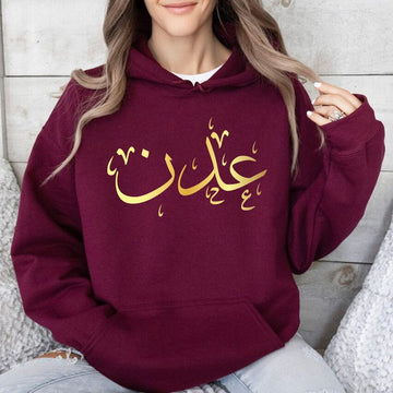 Personalised Arabic Name Hoodie designed for Muslims, Arabic speakers, Islamic fashion lovers, students, family members, friends, and anyone who appreciates meaningful personalised clothing. Featuring a bold Arabic calligraphy name design printed across the chest, this premium hoodie combines cultural identity, personal expression, and modern fashion styling. Perfect for customers searching personalised Arabic clothing, Arabic name apparel, Muslim fashion hoodies, Islamic gifts, custom Arabic typography gar