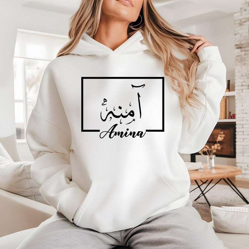 1. Audience-Focused ALT
Personalised Arabic Name Hoodie designed for Muslim women, Arabic culture enthusiasts, and anyone seeking meaningful personalised clothing. This elegant black hoodie features a custom Arabic calligraphy name design printed in luxurious gold within a minimalist frame. Perfect for daughters, sisters, wives, mothers, friends, and loved ones who appreciate personalised apparel that combines identity, culture, comfort, and timeless style while expressing individuality through elegant Arab