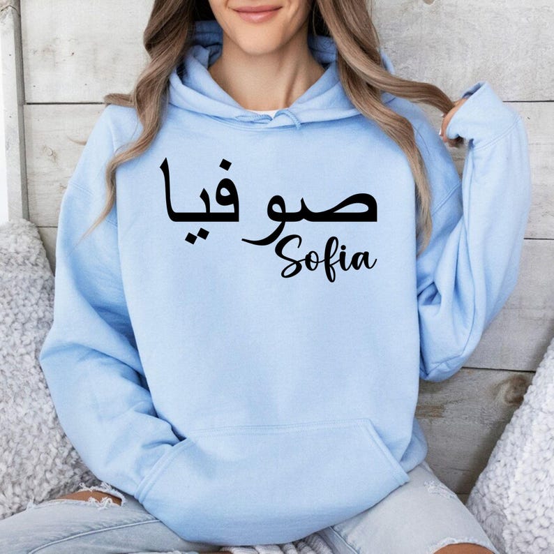 Custom Arabic Name Hoodie personalised with your chosen Arabic text and professionally printed in an elegant calligraphy style on both the front and back. This unique personalised hoodie transforms a meaningful name into a stylish fashion statement while creating a memorable keepsake for everyday wear. Ideal for customers searching personalised Arabic hoodies, custom name clothing, Arabic calligraphy fashion, personalised Muslim gifts, Islamic apparel, Arabic typography clothing, and premium custom garments