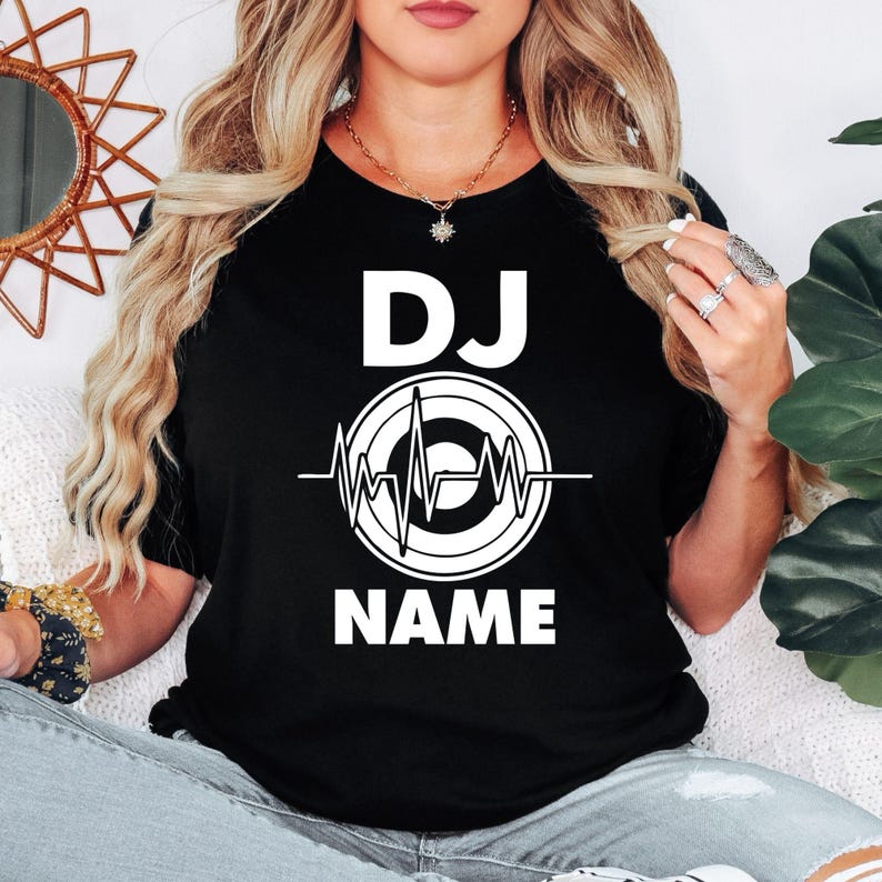 Perfect for DJs, music producers, festival performers and electronic music lovers, this personalised DJ shirt features a custom DJ name with a modern heartbeat turntable graphic. Designed for gigs, studio sessions and casual everyday wear, every premium t-shirt is professionally printed in the UK by TeezoraPrints using high-quality materials for exceptional comfort and durability.