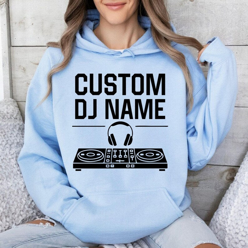 Show your passion for music with this personalised DJ hoodie featuring a custom name, headphones and controller graphic. Whether mixing tracks, performing live, attending festivals or relaxing with friends, this premium hoodie offers comfort and standout style. Every hoodie is proudly printed in the UK by TeezoraPrints.