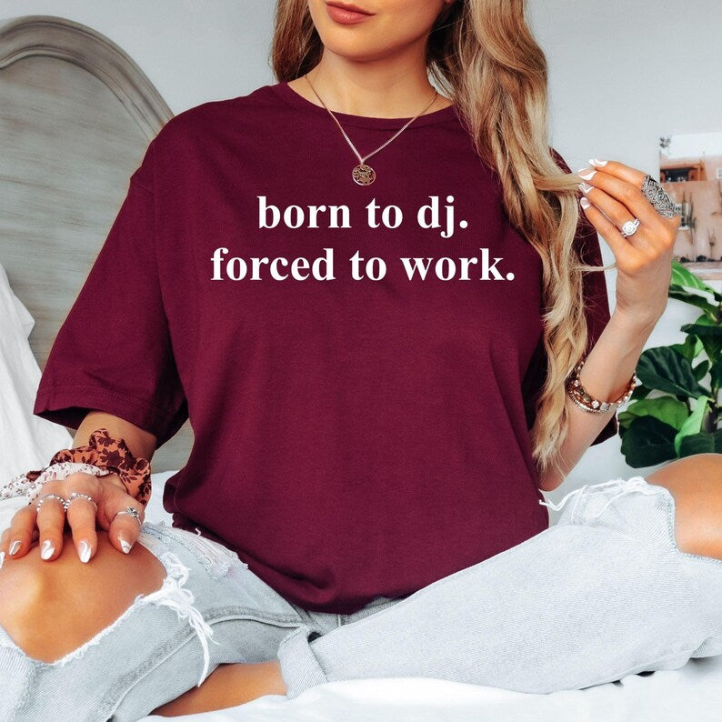 If music is your real career and work simply pays the bills, this Born To DJ Forced To Work t-shirt is made for you. Featuring a bold minimalist design with premium printing, it's the perfect choice for DJs, producers and festival lovers who enjoy funny statement clothing. Soft cotton fabric, relaxed unisex fit and outstanding quality make this shirt ideal for everyday wear. Every piece is professionally printed in the UK by TeezoraPrints.