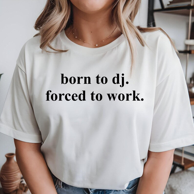 Designed for DJs, music producers, club performers, EDM fans and electronic music lovers, this graphic t-shirt features the bold slogan "Born To DJ. Forced To Work." Perfect for anyone who would rather be behind the decks than stuck at a day job. Whether you're performing live, producing tracks, entertaining at private events or showing your passion for music, this premium shirt delivers comfort, style and personality. Every order is professionally printed in the UK by TeezoraPrints using premium-quality 