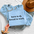 Celebrate your DJ lifestyle with this Born To DJ. Forced To Work. sweatshirt featuring a clean typography design that every music lover will appreciate. Whether you're mixing tracks, travelling to gigs, producing beats or relaxing between performances, this premium crewneck delivers warmth, comfort and standout style. Every sweatshirt is proudly printed in the UK by TeezoraPrints.