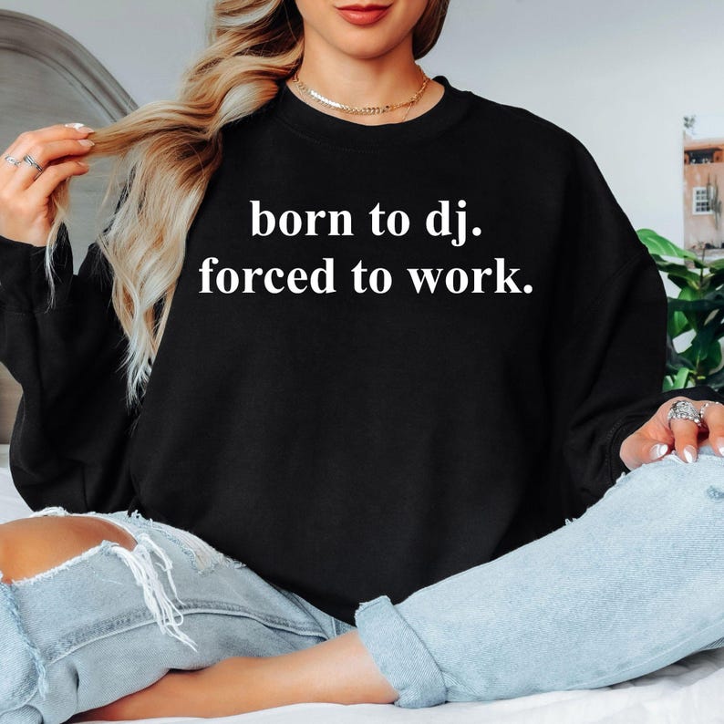 Designed for DJs, music producers, club performers and electronic music enthusiasts, this Born To DJ. Forced To Work. sweatshirt is perfect for anyone whose true passion is making music. Featuring a bold typography design with a humorous message, it's ideal for studio sessions, club nights, festivals and everyday wear. Every premium crewneck is professionally printed in the UK by TeezoraPrints using high-quality materials for exceptional comfort and durability.