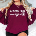 Create your own personalised DJ Name Heartbeat Sweatshirt by adding any custom DJ name. Featuring a heartbeat waveform connected to a vinyl record, this premium crewneck is perfect for DJs and music lovers. Professionally printed in the UK by TeezoraPrints for outstanding comfort and long-lasting quality.