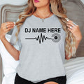 Featuring a custom DJ name, heartbeat waveform and vinyl record graphic, this personalised t-shirt creates a clean modern look for DJs and music lovers. Professionally printed in the UK by TeezoraPrints using premium-quality materials.