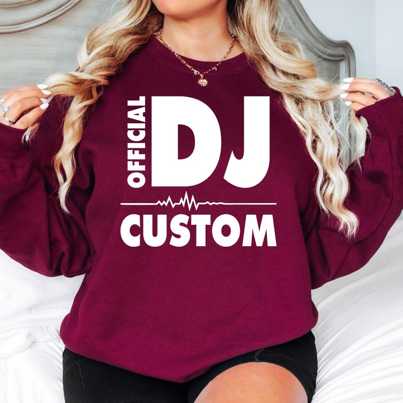 Create your own personalised Official DJ Heartbeat Sweatshirt by adding any name beneath the bold DJ design. Featuring a modern heartbeat waveform and premium-quality fabric, this crewneck delivers comfort, warmth and standout style for DJs, producers and music lovers. Professionally printed in the UK by TeezoraPrints with durable, long-lasting print quality.