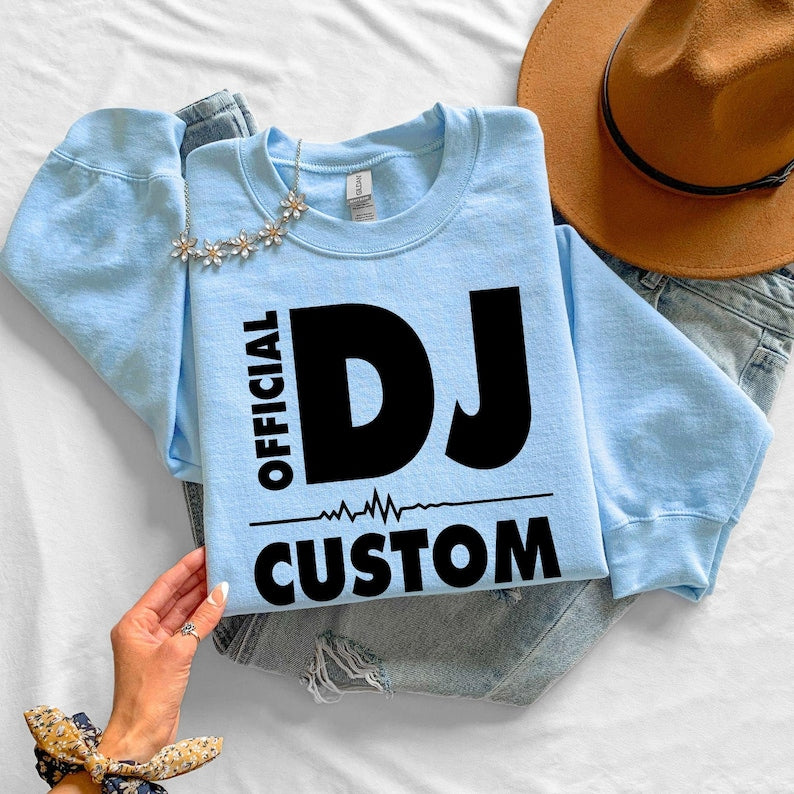 Celebrate your love for music with this personalised Official DJ Heartbeat Sweatshirt featuring bold typography, a heartbeat waveform and your custom name. Whether you're performing behind the decks, producing tracks or attending your favourite festival, this premium crewneck offers warmth, comfort and standout style. Printed in the UK by TeezoraPrints.