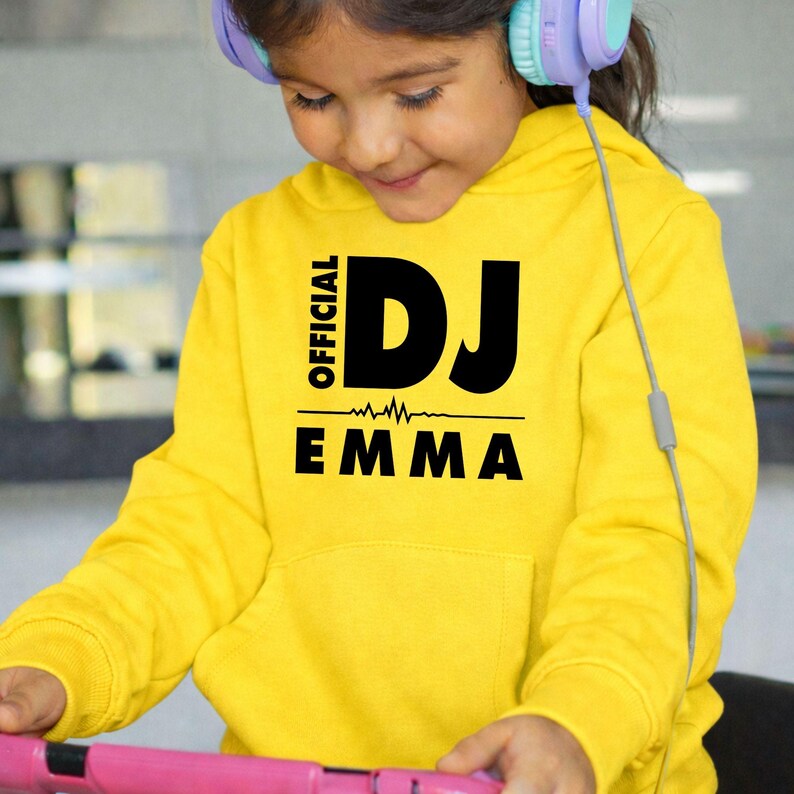 Show your passion for music with this personalised Official DJ Heartbeat Hoodie featuring a custom name, heartbeat waveform and bold Official DJ typography. Whether you're behind the decks, producing music or enjoying your favourite festival, this premium hoodie delivers warmth, comfort and standout style. Proudly printed in the UK by TeezoraPrints.