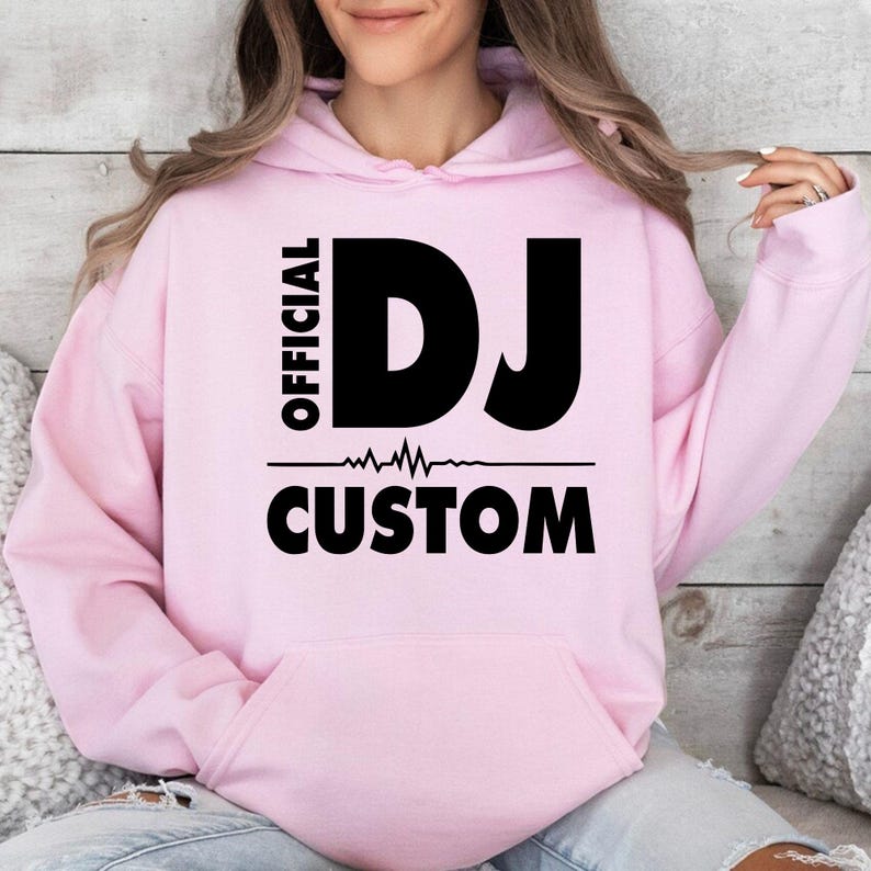 Featuring bold Official DJ lettering, a heartbeat waveform graphic and a personalised custom name, this premium hoodie creates a modern statement look for DJs and music enthusiasts. Professionally printed in the UK by TeezoraPrints, it's designed for lasting comfort, vibrant print quality and everyday wear.