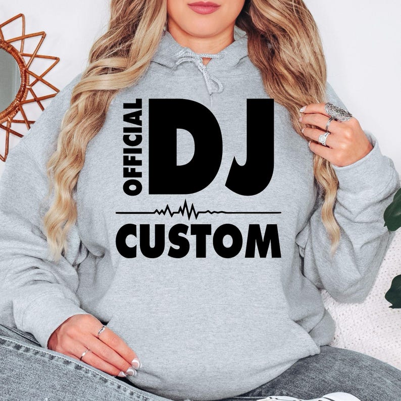 Designed for DJs, remix artists, music producers, club performers and electronic music lovers, this personalised Official DJ Heartbeat Hoodie celebrates DJ culture with bold typography, a heartbeat waveform and a custom name. Every premium hoodie is professionally printed in the UK by TeezoraPrints for exceptional comfort, durability and standout style.