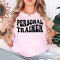 Personal Trainer T Shirt makes a thoughtful gift for personal trainers, fitness instructors, gym owners, bodybuilding coaches, sports coaches, exercise professionals, CrossFit trainers, family members, friends, colleagues, and anyone passionate about health and fitness. Designed by Teezora Prints, this premium graphic shirt is perfect for birthdays, Christmas, gym anniversaries, fitness competitions, appreciation gifts, and motivational presents for fitness professionals.