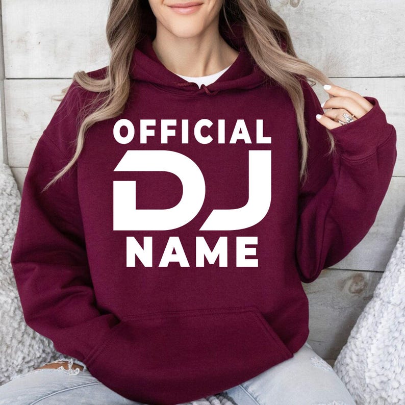 Stand out with this personalised Official DJ hoodie featuring your custom DJ name in a bold eye-catching design. The soft premium fabric, relaxed unisex fit and professional print make it perfect for DJs, performers and music enthusiasts. Every hoodie is made to order and professionally printed in the UK by TeezoraPrints for a premium finish.
